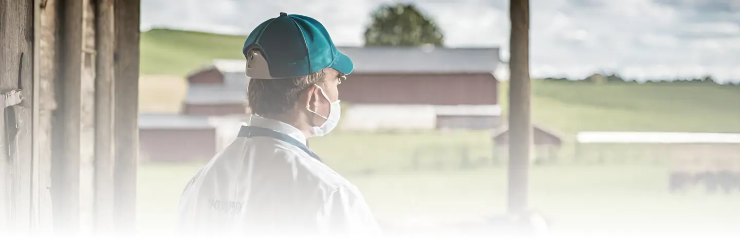 AI generated image of a veterinarian looking over a cattle ranch and barn on Kreative DocuVet About Us page